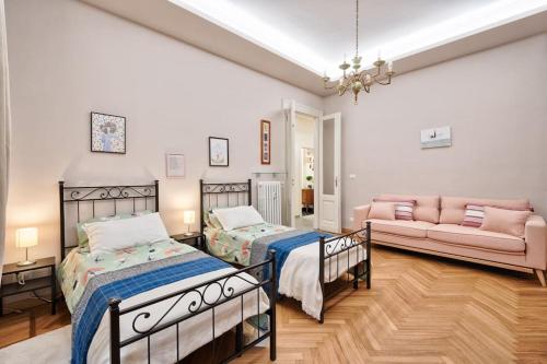una camera con due letti e un divano in camera di CASA AGNESE a Torino