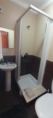 uma casa de banho com um chuveiro e um lavatório. em Guesthouse, Ap Veríssimo na Nazaré