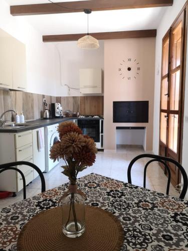 a kitchen with a table with a vase with flowers on it at Villa Calcerame in Montelepre