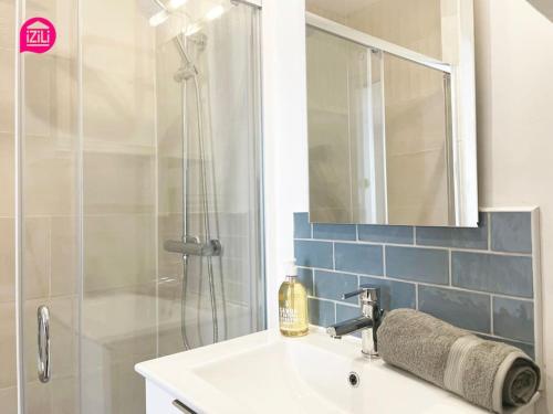 une salle de bain avec un lavabo et une douche avec un miroir dans l'établissement Le Studio Marin by CozyLife - Centre Ville - Gare, à Niort