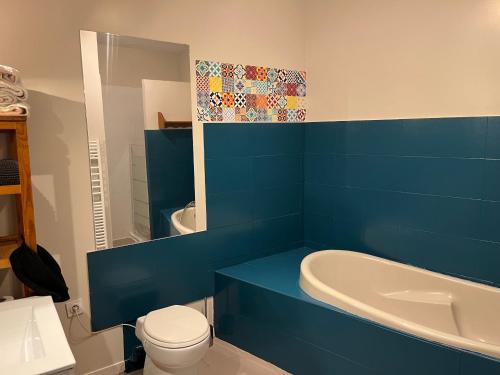 Baño azul con bañera, aseo y lavamanos en Lbkn, en Toulouse