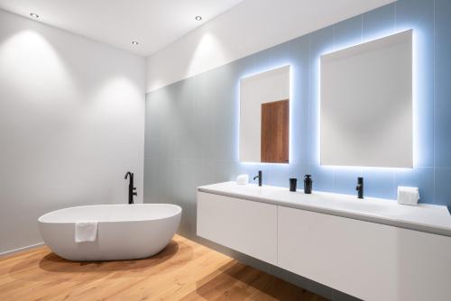 a bathroom with a white tub and a mirror at Swiss Hotel Apartments - Engelberg in Engelberg