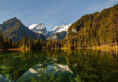 a view of a lake with mountains in the background at Relax- & Wanderhotel Poppengut in Hinterstoder