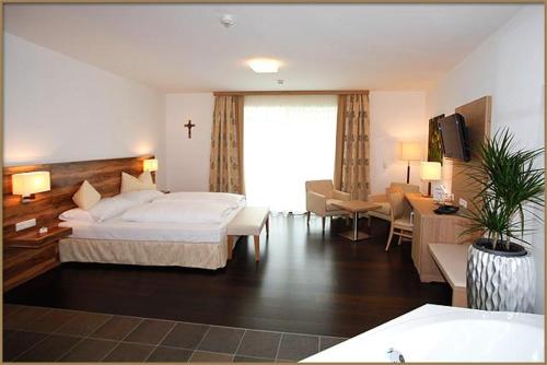 a hotel room with a bed and a living room at Relax- & Wanderhotel Poppengut in Hinterstoder