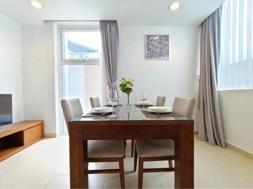 a dining room with a table and chairs and a window at Glenwood Residences in Ho Chi Minh City