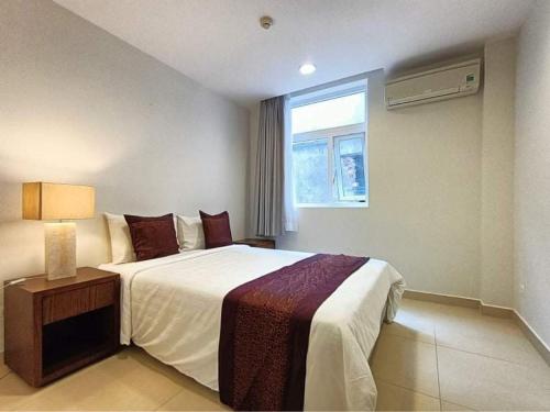 a bedroom with a large bed and a window at Glenwood Residences in Ho Chi Minh City