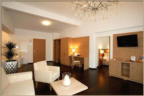 a living room with a couch and a living room with a television at Relax- & Wanderhotel Poppengut in Hinterstoder