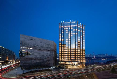 a tall building in a city at night at Courtyard by Marriott Suwon in Suwon