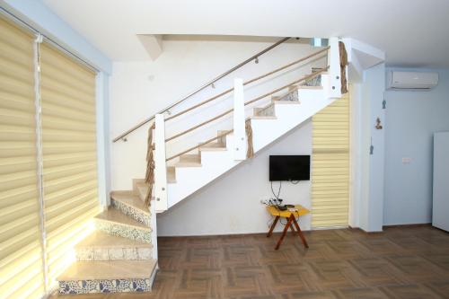 a staircase in a home with white walls and wood floors at Sweet Home Shekvetili 1 in Shekvetili