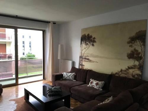 un soggiorno con divano e una grande finestra di résidence Garches -St Cloud a Rueil-Malmaison
