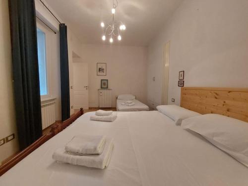 1 dormitorio con 1 cama blanca grande y toallas. en La Terrazza, en Trieste