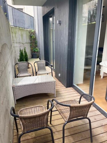 a patio with three chairs and a table on a balcony at Rimos apartamentai Juodkranteje in Juodkrantė