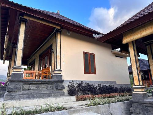a house with a porch with a chair on it at The babakan accommodations in Sidemen