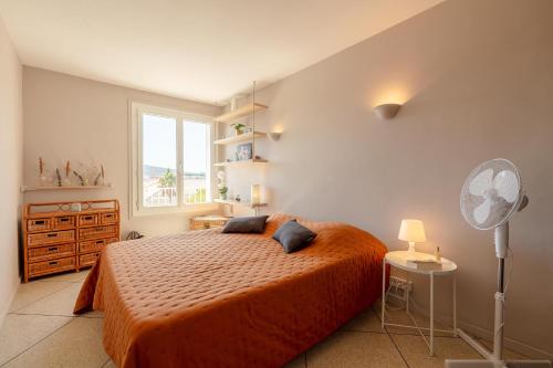 - une chambre avec un lit doté d'un couvre-lit orange et d'une fenêtre dans l'établissement Le Blue Sea - Appt T3 classé 3 étoiles à 650m de la plage, au Lavandou
