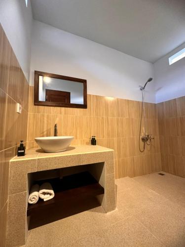 a bathroom with a sink and a mirror at The babakan accommodations in Sidemen