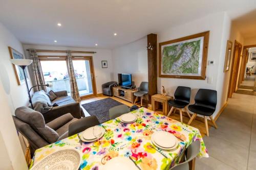 un salon avec une table et des chaises dans l'établissement Grand Paradis B01 - Modern with great location, à Chamonix-Mont-Blanc