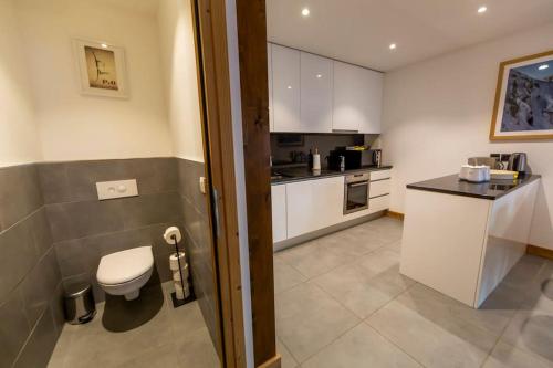 une petite cuisine avec des toilettes et un comptoir dans l'établissement Grand Paradis B01 - Modern with great location, à Chamonix-Mont-Blanc