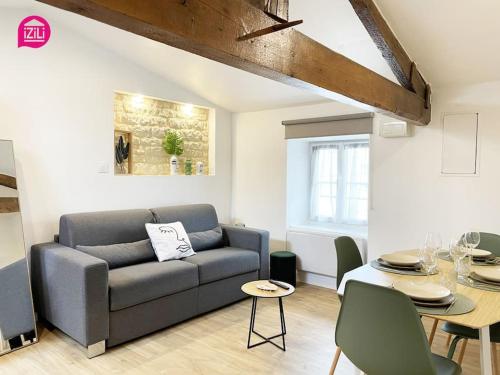 un salon avec un canapé et une table dans l'établissement La Brèche Niortaise by CozyLife - Centre Ville- Gare, à Niort