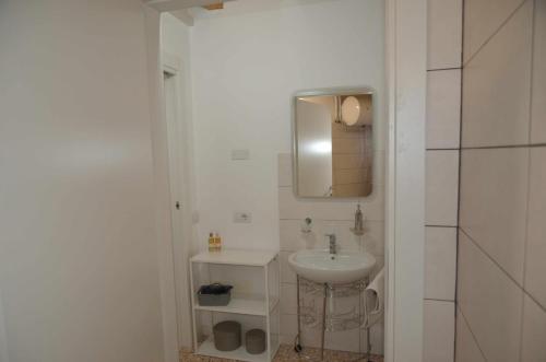 ein weißes Badezimmer mit einem Waschbecken und einem Spiegel in der Unterkunft Palazzo Maggiore Suite A in Noale