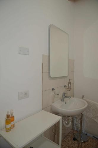 a white bathroom with a sink and a mirror at Palazzo Maggiore Suite A in Noale