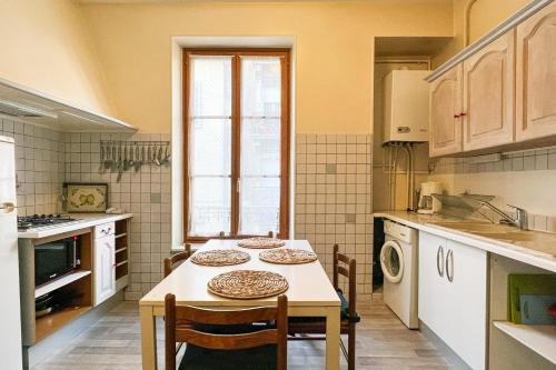 a kitchen with a table and some chairs and a table and a kitchen at Marx Residence T2 4 personnes - Wifi #EA in Grenoble