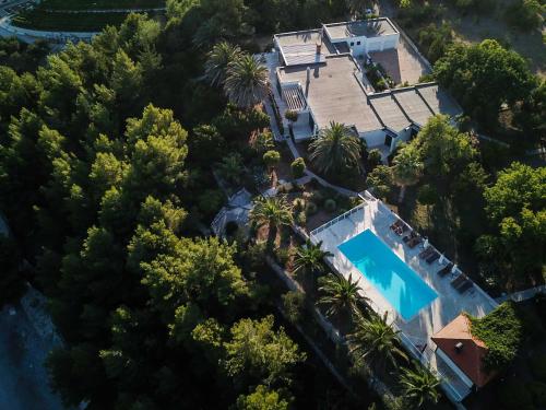 an aerial view of a house with a swimming pool and trees at Villa Peljesac Majestic A Beautiful 8 Bedroom Villa Short Stroll Down the Path to the Beach in Orebić