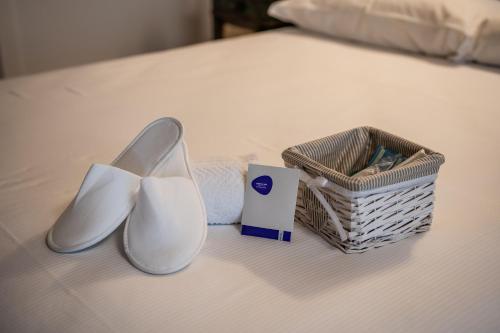 a pair of shoes and a basket on a bed at Agriturismo Il Bosco Camere in Vittorio Veneto
