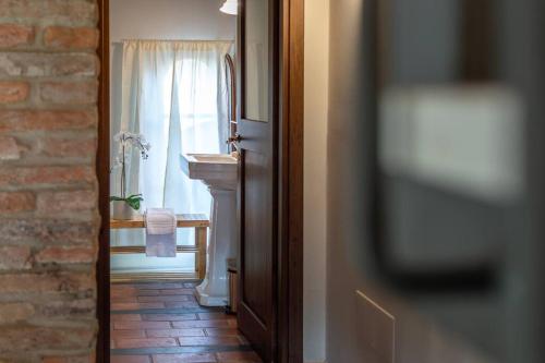 a bathroom with a sink and a window at AffittiBreviSiena - Palazzo Monaci Appartamento con piscina nelle crete Senesi in Asciano