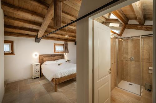 a bedroom with a bed and a shower at Agriturismo Il Bosco Camere in Vittorio Veneto