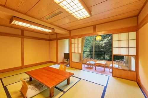 a room with a table and chairs and a window at Hakone Yumoto hotel in Hakone