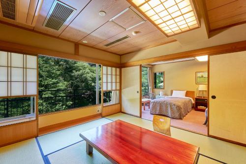 a bedroom with a bed and a table in a room at Hakone Yumoto hotel in Hakone