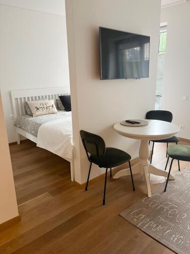 耶德库安特Rimos apartamentai Juodkranteje的一间卧室，配有一张床、一张桌子和几把椅子