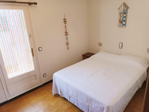 a bedroom with a white bed and a window at Costa brava apartment, Estartit in Torroella de Montgrí