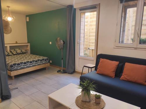 uma sala de estar com um sofá e uma cama em Studio spacieux aux portes de la Camargue em Beauvoisin