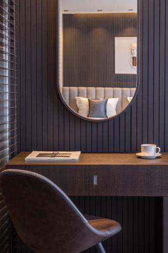 a table with a chair and a mirror at Derand Hotel in Pristina