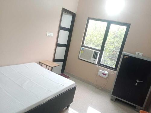 a bedroom with a bed and a window at OYO Bhavya Guest House in Morādābād