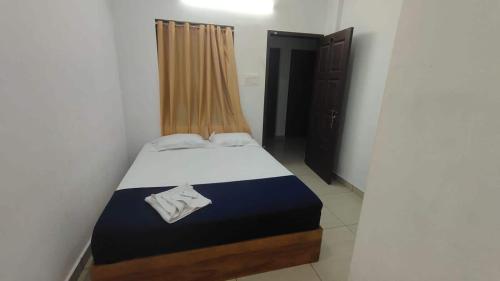 una piccola camera con un letto in una stanza di SPOT ON SB Guest House a Alleppey