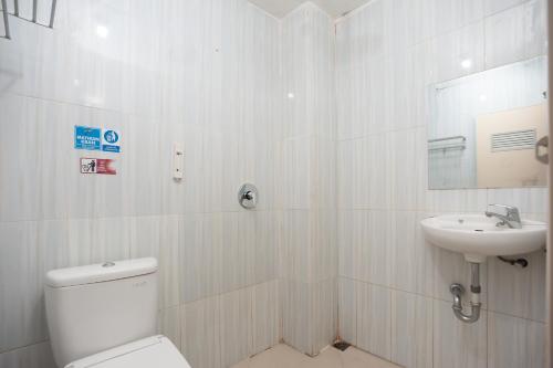 biała łazienka z toaletą i umywalką w obiekcie AVA Guesthouse Mitra RedDoorz Lampung w mieście Bandar Lampung