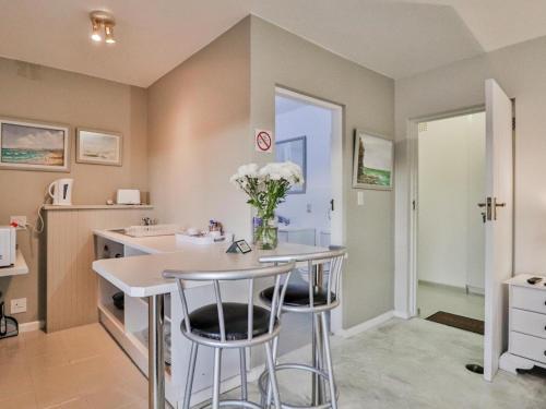 a kitchen with a sink and a counter with stools at Glenview Heads Apartments in Knysna