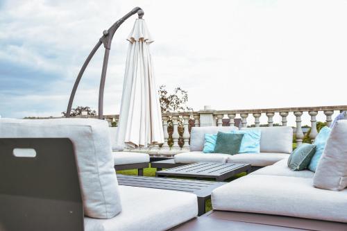 a patio with couches and a laptop on a table at B&B Fruithof Tack in Sint-Gillis-Waas