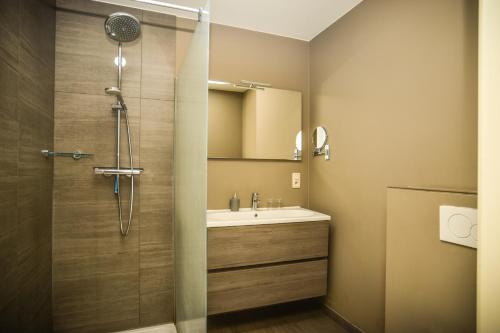 La salle de bains est pourvue d'une douche et d'un lavabo blanc. dans l'établissement B&B Fruithof Tack, à Saint-Gilles-Waes
