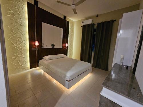 a bedroom with a bed and a mirror on the wall at Blue Haven Retreat in Thulusdhoo