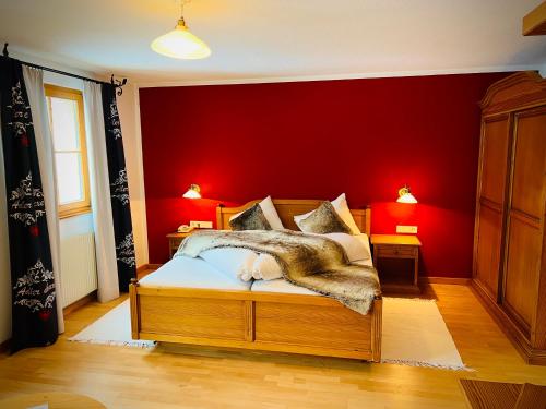 a bedroom with a bed with a red wall at Hotel Gasthof Adler in Sankt Gallenkirch