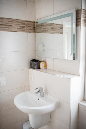 a white bathroom with a sink and a mirror at Havelstern Ketzin, Ferienhaus Hecht in Ketzin