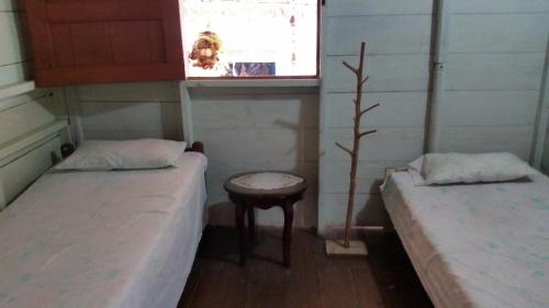 a small room with two beds and a window at Posada Ecoturística El Valle in El Valle