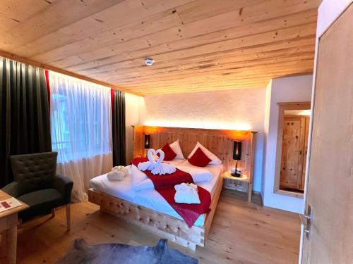 a bedroom with a large bed with towels on it at Hotel Gasthof Adler in Sankt Gallenkirch