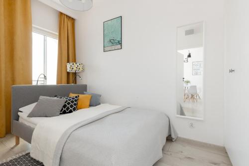 a white bedroom with a bed and a window at Pet-Friendly Apartment Prymasa Tysiąclecia by Renters in Warsaw