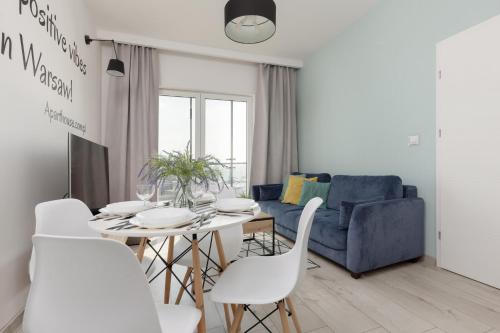 sala de estar con mesa y sofá azul en Pet-Friendly Apartment Prymasa Tysiąclecia by Renters, en Varsovia