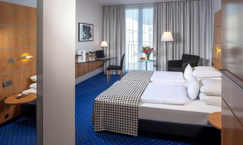 a hotel room with a bed and a desk at Dorint Hotel Potsdam in Potsdam