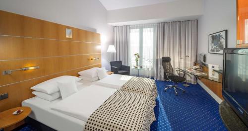 une chambre d'hôtel avec un lit et une télévision dans l'établissement Dorint Sanssouci Berlin/Potsdam, à Potsdam